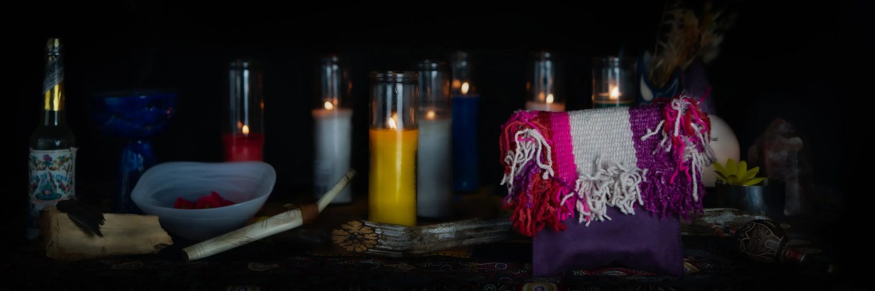 A woven textile satchel with bright fringe on a ceremony table