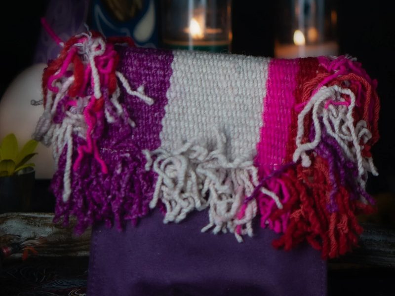 A woven textile satchel with bright fringe